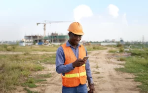 Construction worker checking remittance transfer on their phone.