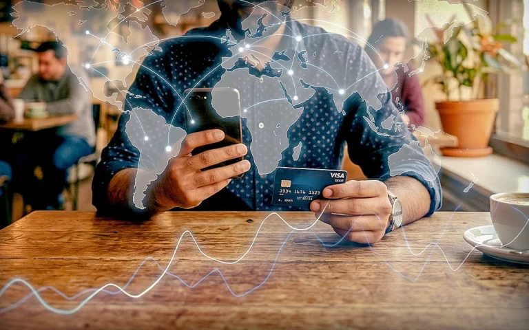 Person using a smartphone and a credit card with a global network overlay, illustrating the effect of remittances on economic growth.